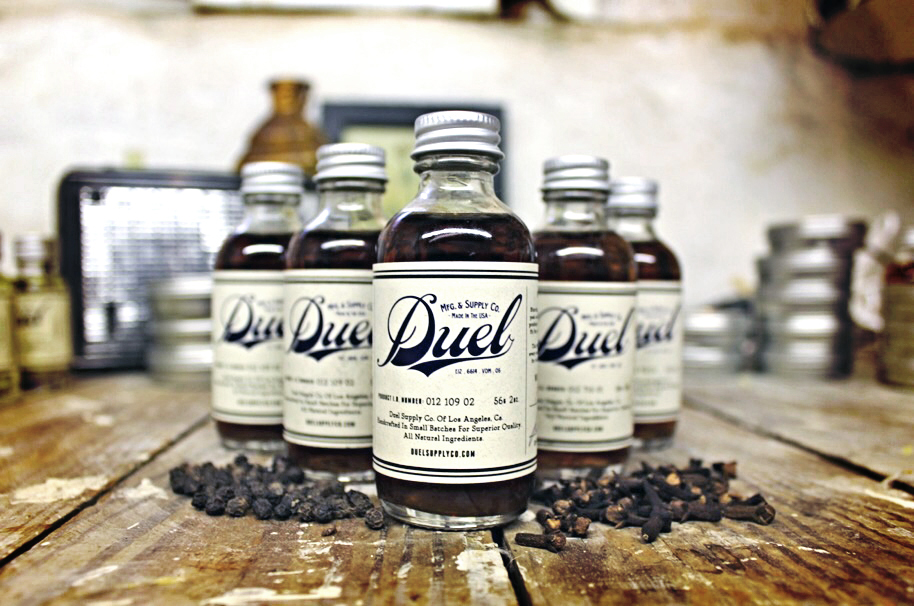 Duel cologne bottles on raw wood with whole cloves