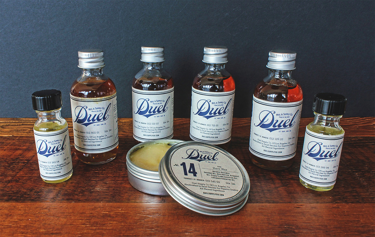 Full Duel product line — bottles and tins on dark wood